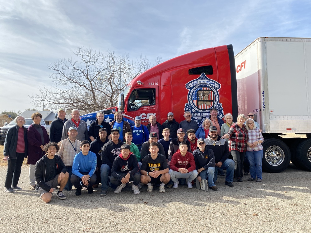 volunteers pose in front of semi truck carrying wreaths