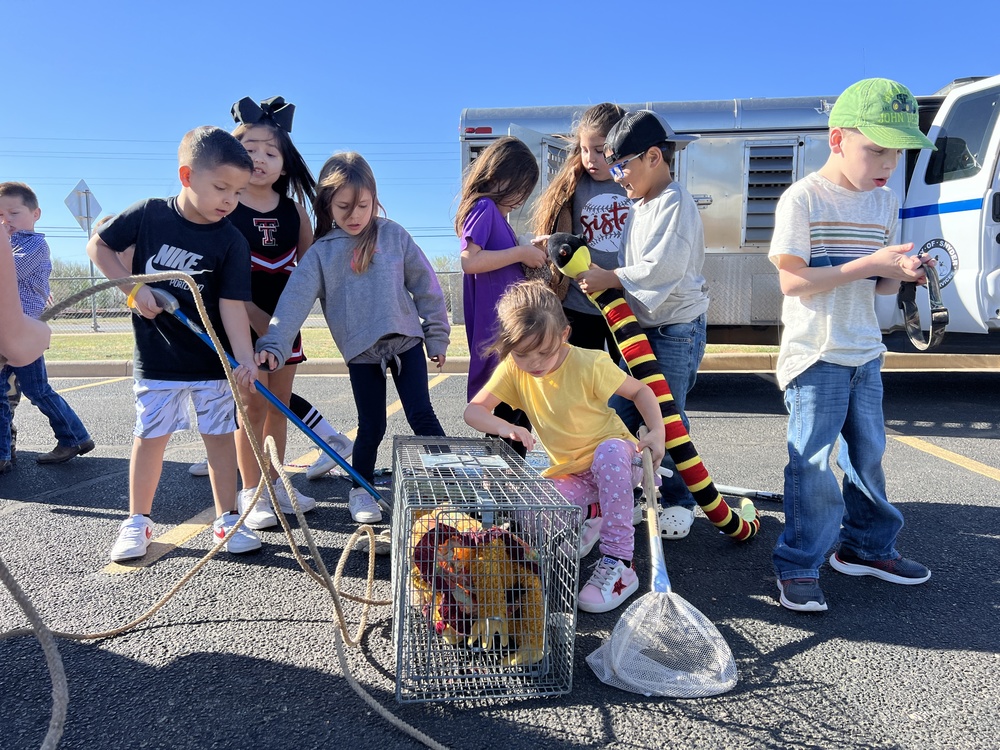 young students pretending to rescue animals in trap for career day