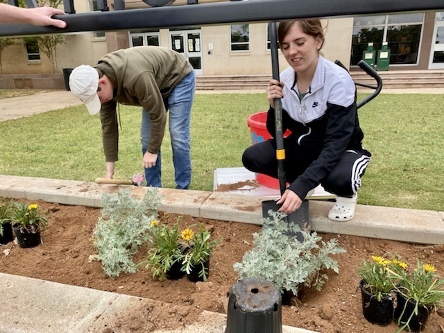 students planting flowers