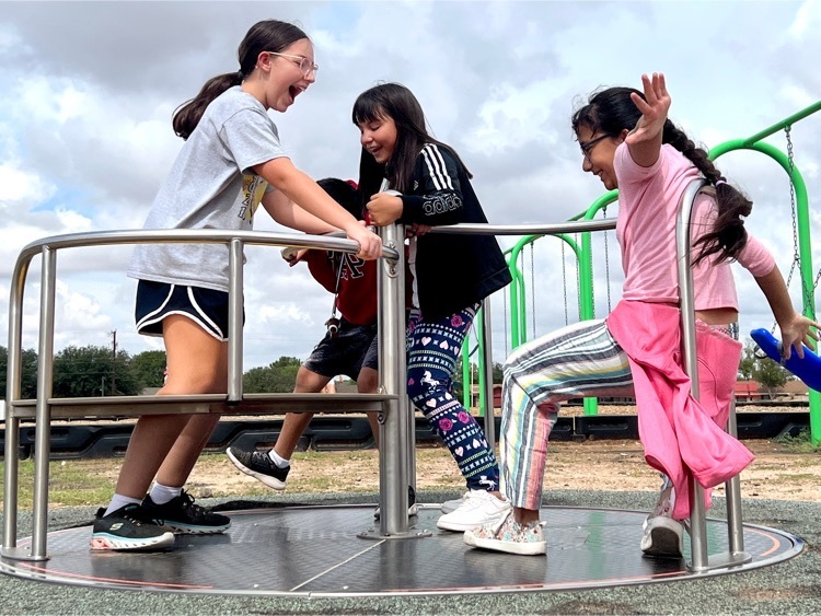 students smiling on merry go round 