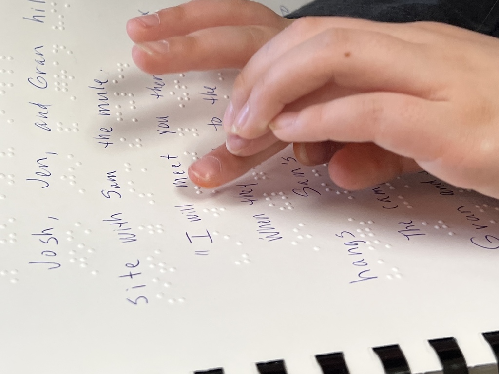 student reading braille book 