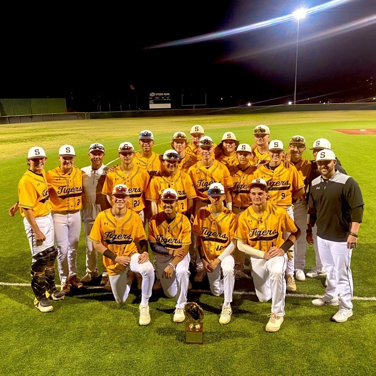 photo of baseball team smiling with golden glove trophy 