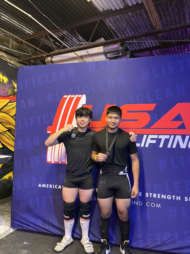 students holding powerlifting medals