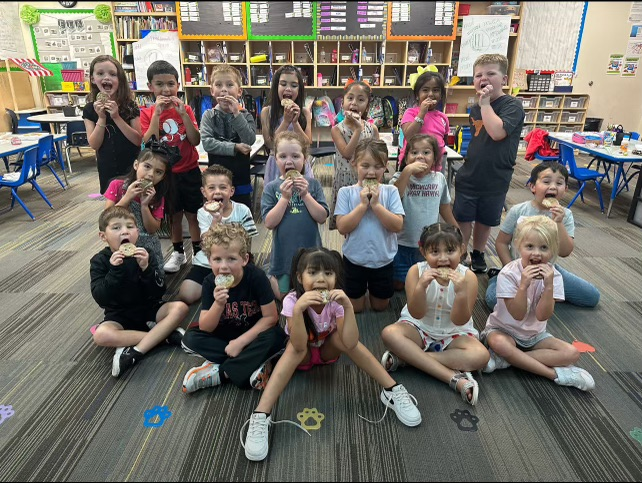 Winning class posing for a picture with cookies in their mouth