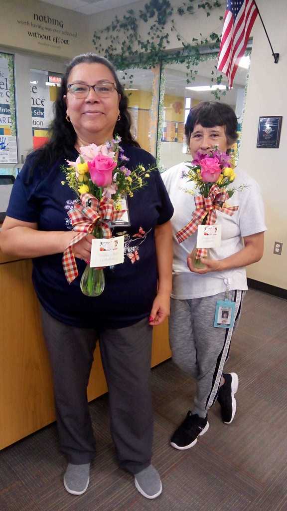 custodians posing with flowers