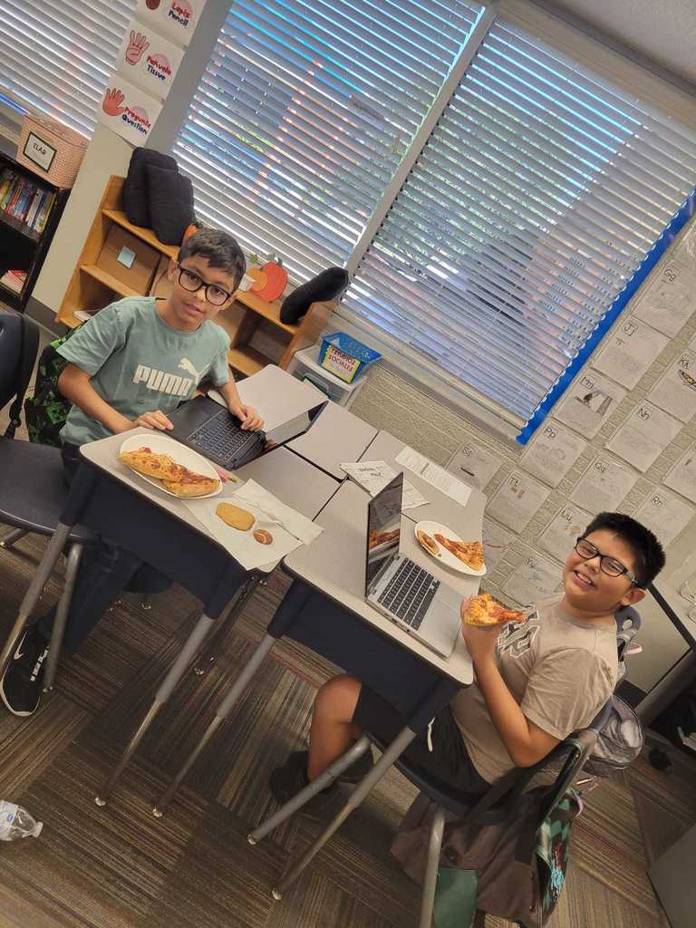 students posing with pizza